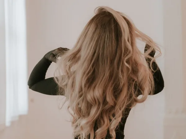 Long blonde waves photographed from behind
